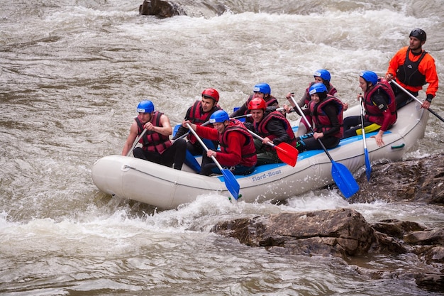 Cárpatos Ucrania Mayo 012015Equipo de rafting salpicando las olas rafting deporte extremo y divertidoGrupo de personas con guía rafting en aguas bravas y remo en barco de raftingdeporte extremo