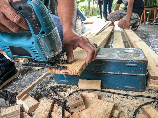 Carpenter estaba aserrando la madera para crear paredes y decoración de madera, su servicio trabajó en el sitio en la casa del cliente.