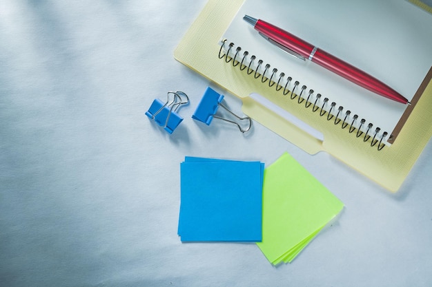 Carpeta de papel de cuaderno, bolígrafo biro, clips de documentos, recordatorios adhesivos