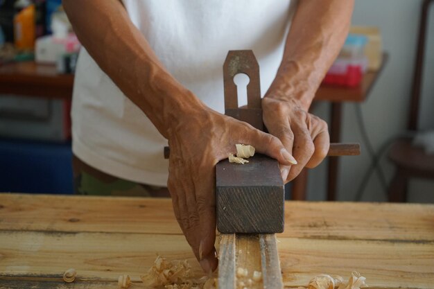 Foto carpinteiros de madeira e móveis estão usando spokeshave para decorar a madeira