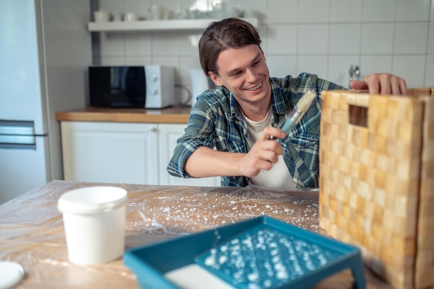 Foto carpintero aplicando una capa de pintura a la caja de madera