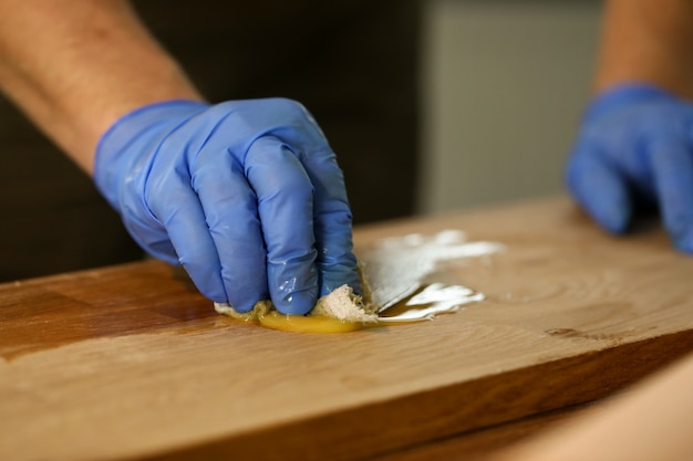 El carpintero con guantes hace el tratamiento hidrotermal de madera