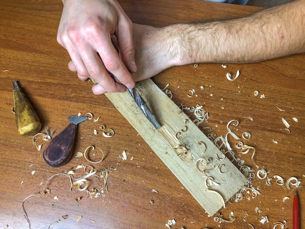 Carpintero hace su trabajo, procesando madera a mano.