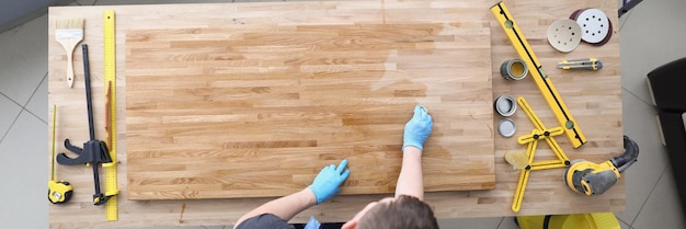 Foto carpintero hombre práctico tablón de madera lacado en el taller