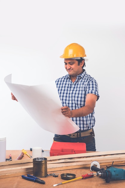 Carpintero indio guapo o trabajador de la madera en acción, aislado