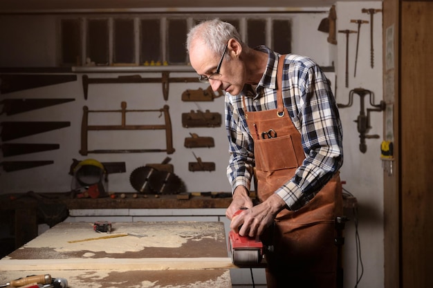 Carpintero lijando madera con lijadora de banda en taller en proyecto de tablero de madera o carpintería de carpintería Material de archivo 4k de alta calidad