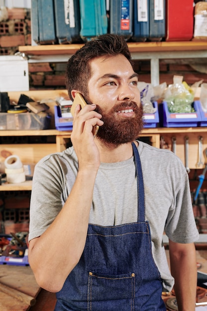 Foto carpintero llamando por teléfono con el cliente