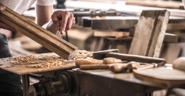 Carpintero macho trabajando con un producto de madera, herramientas manuales