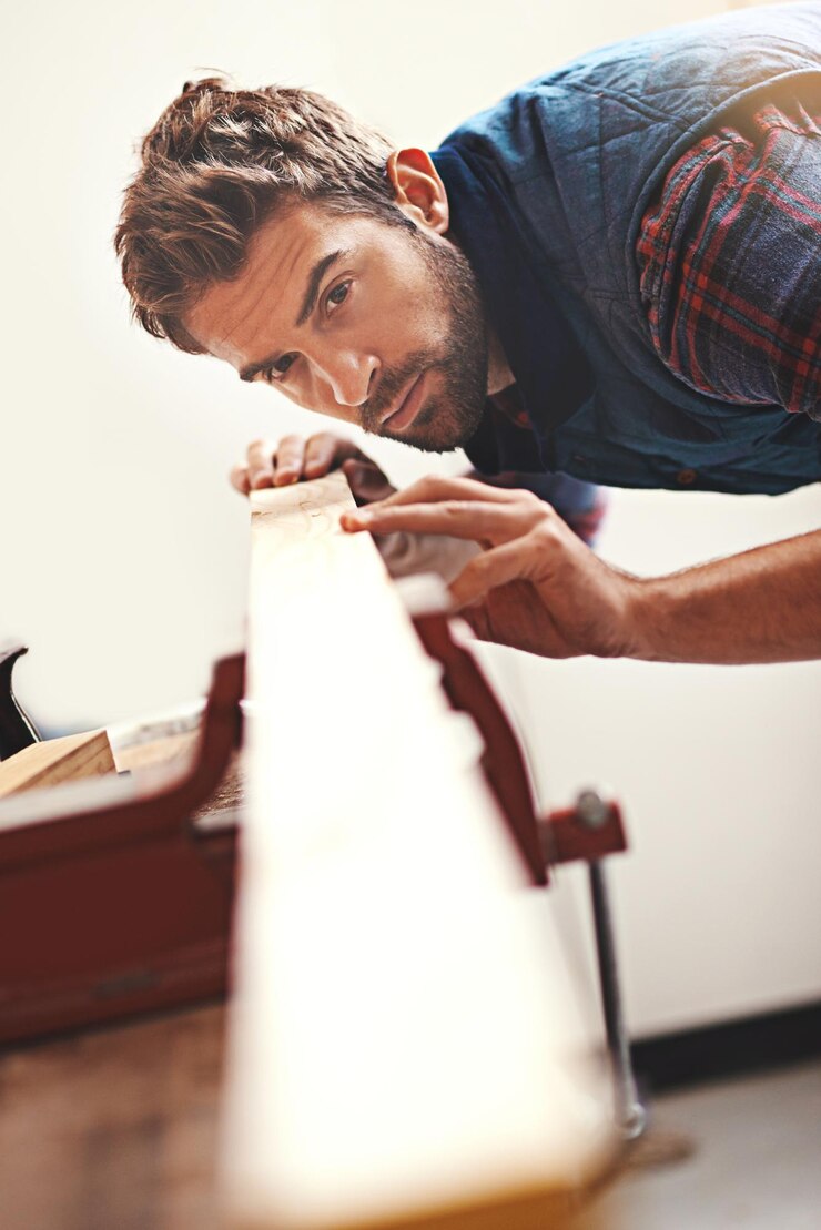 Foto carpintero de madera y planificación con el hombre en el taller para la industria de la construcción y el diseño creativo y carpintero con manitas que miden en el banco de trabajo para la construcción de madera y mantenimiento