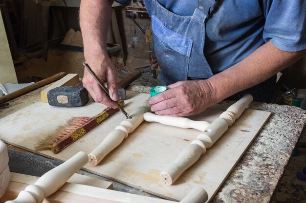 carpintero monta una silla de madera en un banco de trabajo