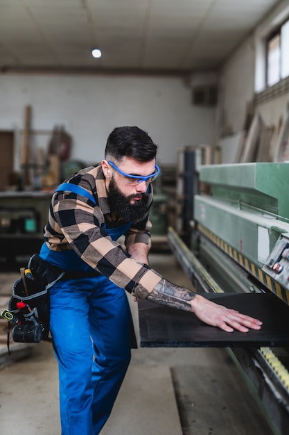 Foto carpintero profesional enfocado que trabaja en su taller, concepto de carpintería y artesanía.