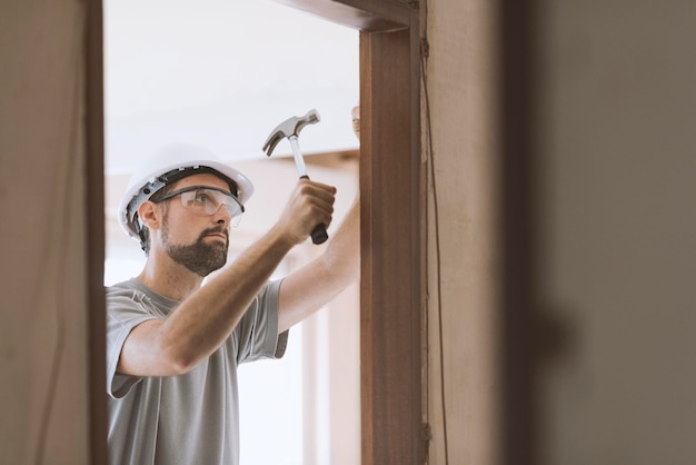 Carpintero profesional instalando un concepto de carpintería y renovación del hogar con jamba de puerta