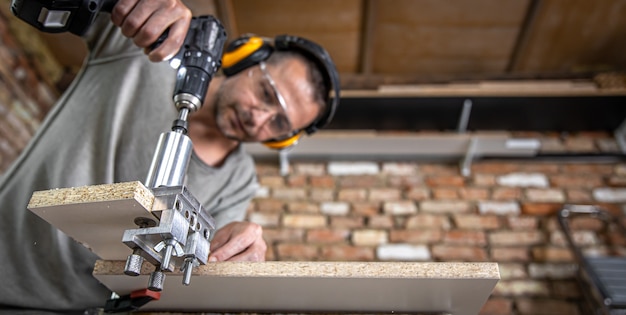 Carpintero profesional que trabaja con madera y herramientas de construcción en casa.