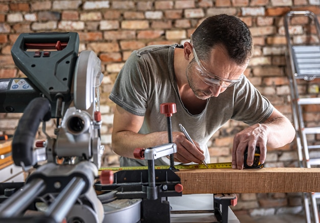Un carpintero profesional trabaja con una sierra circular para cortar ingletes en un taller.