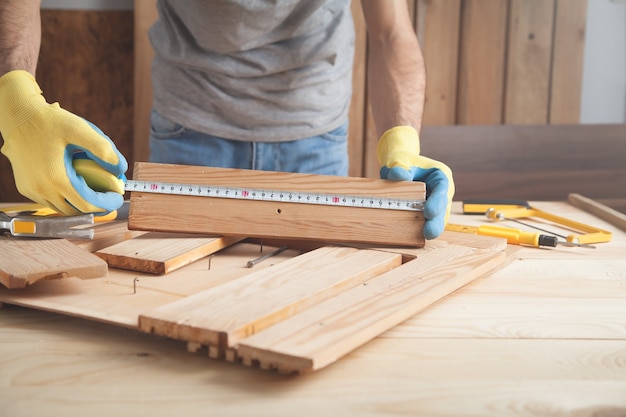 Foto carpintero con regla tablón de madera de medición