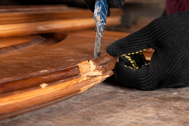 Carpintero restaurando puertas de madera antiguas, trabajar en el taller de cerca