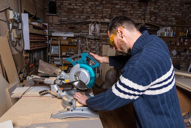 Un carpintero trabaja en un taller de muebles.