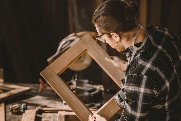 Carpintero trabajador constructor de madera masculino haciendo trabajo de muebles de madera en el taller