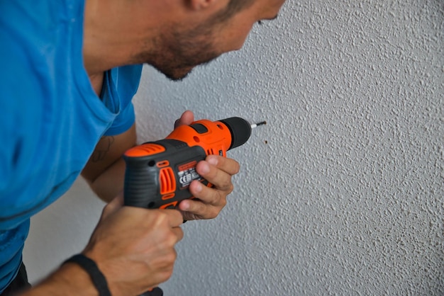 Carpintero trabajando con cuidado, hombre perforando una pared. Trabajando en casa.