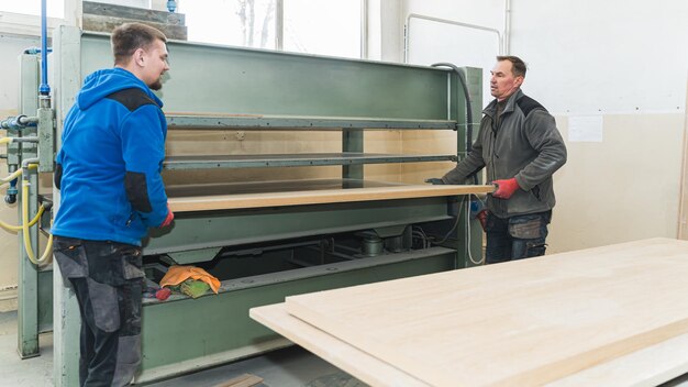 Carpinteros que se deslizan en paneles de madera en artesanos de molineras de cinturón