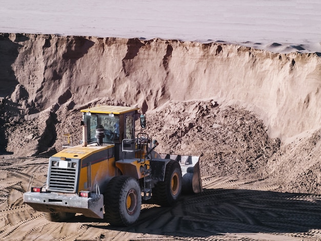 Carregadeira de trator trabalhando em uma caixa de areia