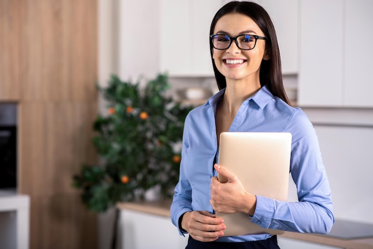 Foto carregado de positividade alegre mulher simpática segurando seu laptop na cozinha