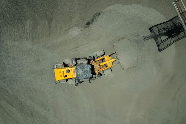 Carregadores de areia estão jogando pedras em caminhões basculantes