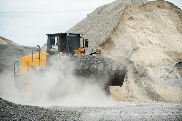 Carregadores de areia estão jogando pedras em caminhões basculantes