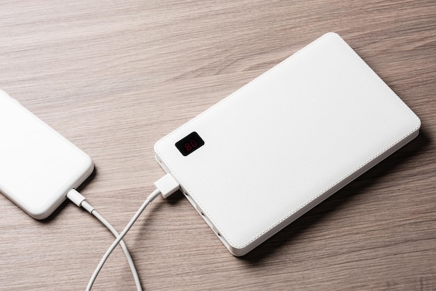 Foto carregar o smartphone de bateria vazia com um banco de energia branco