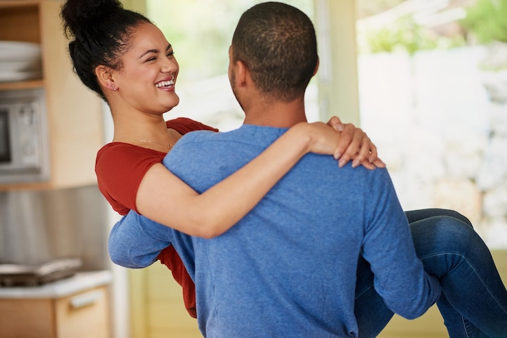 Foto carregar rir e amor com o casal na cozinha da casa juntos para relacionamento de ligação ou romance data feliz ou sorrir com homem e mulher tolos se divertindo no apartamento para comédia ou humor