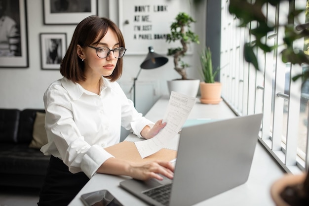 Carreira de empreendedorismo bem-sucedida, senhora feliz sentada à mesa com laptop lendo documento no café