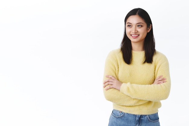 Carrera estudiantil, concepto de rostro hermoso. Atractiva joven asiática con pelo corto oscuro mirando a la izquierda en publicidad de espacio en blanco, sonriendo feliz