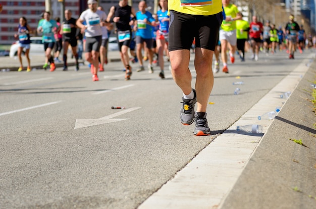 Carrera de maratón, muchos pies de corredores en carreras de carretera, competición deportiva, fitness y concepto de estilo de vida saludable