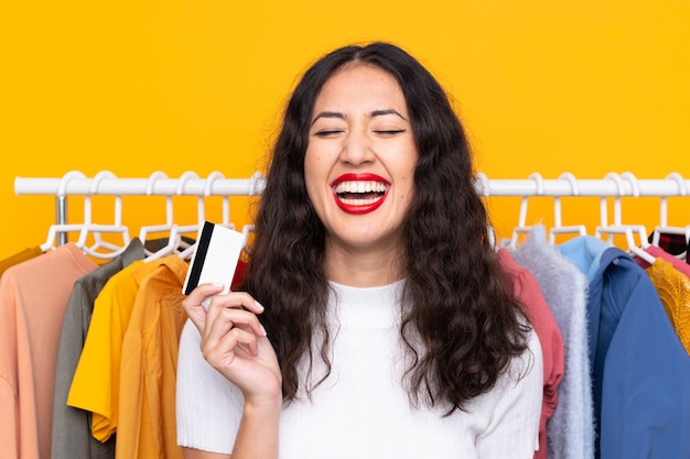 Carrera mezclada, mujer, en, un, tienda de ropa, y, tenencia, un, tarjeta de crédito