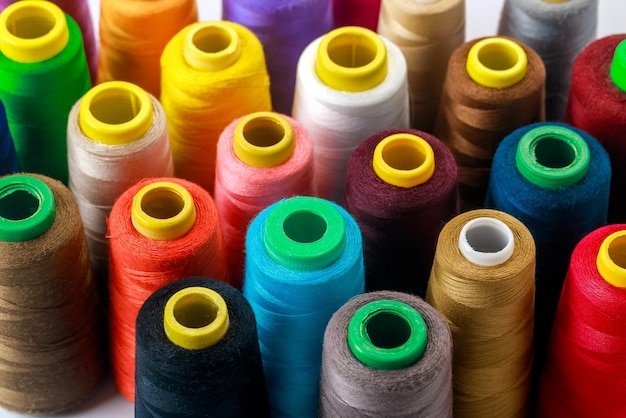 Un carrete de hilo de coser con hilos de colores