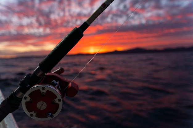 Carrete de pesca en alta mar en un barco durante el amanecer