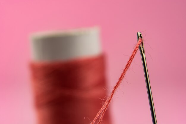 Carretel com linha vermelha e agulha rosa