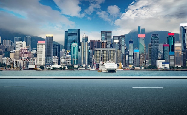 Carretera asfaltada con el centro de negocios del horizonte de la ciudad de Hong Kong con un cielo espectacular