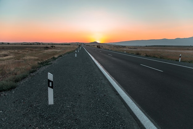 carretera asfaltada con colorida puesta de sol