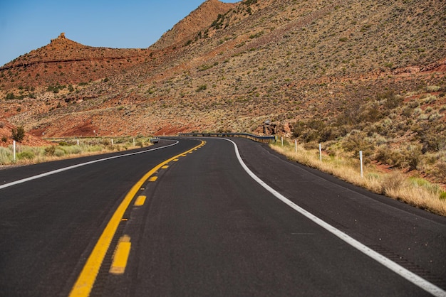 Carretera asfaltada y fondo del cañón Paisaje natural de verano con carretera asfaltada hasta el horizonte