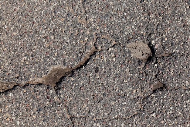 Una carretera asfaltada con muchos hoyos y baches.