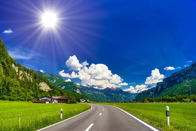 Carretera asfaltada entre prados verdes Brienz InterlakenOberhasli