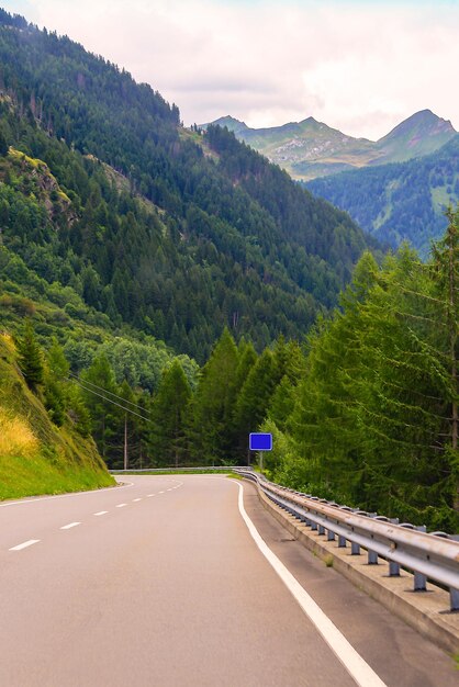 Carretera asfaltada con el telón de fondo de altas cadenas montañosas.