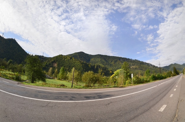 Carretera asfaltada en el terreno montañoso de la mañana.