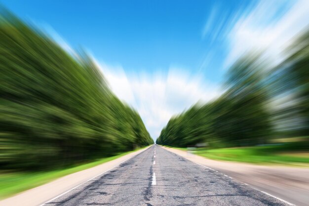 Carretera de asfalto borrosa y cielo de movimiento azul