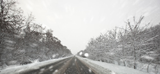 Carretera de asfalto en invierno y nieve afuera