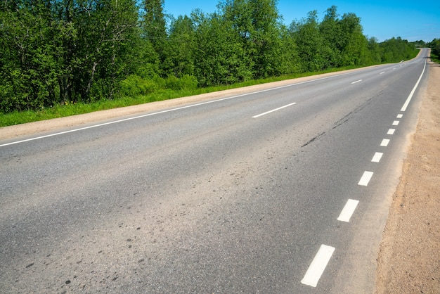 Carretera de asfalto. Marcas viales. Día soleado de verano.