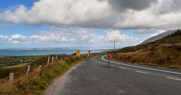 La carretera de asfalto con signos en día soleado