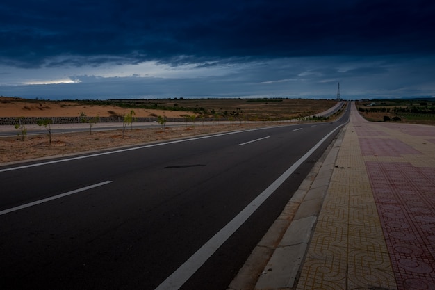 Foto carretera de asfalto a través de la tormenta azul oscuro que viene