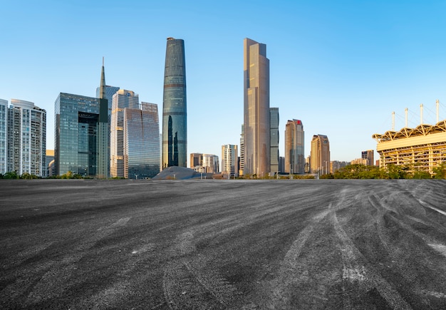 La carretera de asfalto vacía se construye a lo largo de modernos edificios comerciales en las ciudades de China.